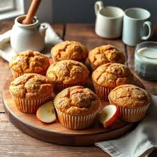 download (10) Muffins integrais de cenoura e maçã dispostos em uma bandeja de madeira