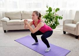 download (11) mulher fazendo agachamento em casa durante treino de pernas