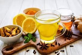 download (16) chá de cúrcuma com limão servido em xícara com raiz fresca e limão ao lado