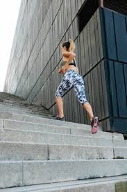 download (19) mulher subindo escadas em casa, praticando exercício funcional.