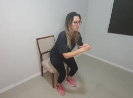 download (20) Mulher se levantando de uma cadeira durante exercício de sentar e levantar