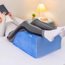 download (3) pés apoiados sobre almofadas com toalha fria e ambiente relaxante.