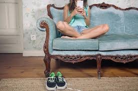 download (5) mulher jovem sedentária segurando o celular.