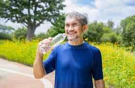 download (10) Idoso hidratando-se com água em clima quente.