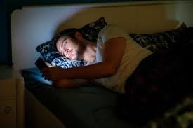 download (12) homem deitado na cama usando o celular antes de dormir