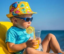 download Criança se protegendo do sol com chapéu e hidratando-se