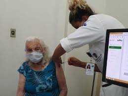 download (16) Enfermeira aplicando vacina contra a gripe em idosa.