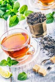 download (2) xícara de chá de rooibos com cor avermelhada sobre mesa de madeira