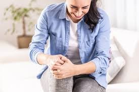 download (2) Pessoa massageando o joelho com expressão de dor