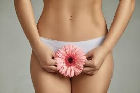 download (20) Mulher segurando flor para representar saúde íntima feminina.