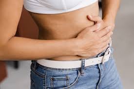 download (30) pessoa com mão no abdômen sentindo desconforto após consumir lactose