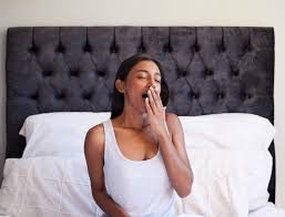 download (4) mulher acordando cansada e bocejando na cama