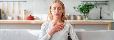 download (58) Mulher segurando o peito com expressão de angústia devido à ansiedade somática.