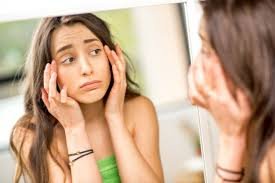 download (74) mulher observando o rosto inchado pela manhã