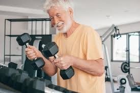 images (5) idoso praticando exercícios de força com halteres leves em academia