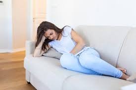 download (2) mulher segurando o abdômen com expressão de dor