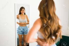 download (29) Mulher olhando para si no espelho, percebendo sinais hormonais