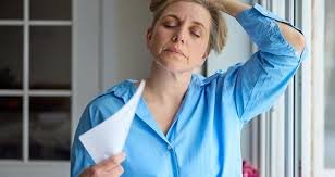 download (31) mulher jovem sentindo calor repentino, sinal comum da menopausa precoce.