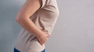 download (40) Mulher com expressão de dor segurando a lateral do abdômen