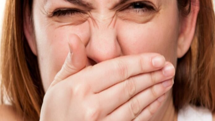 mau-halito-2 Pessoa cobrindo a boca, demonstrando desconforto com o hálito