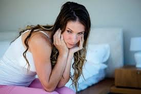 download (47) Mulher pensativa sentada na cama olhando para baixo