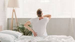 download (12) pessoa segurando as costas ao levantar da cama pela manhã