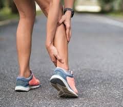 download (17) pessoa segurando o tornozelo com expressão de dor ao caminhar