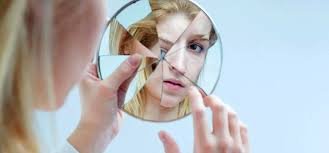 download (2) paciente insatisfeita analisando resultado estético no espelho