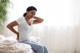 download (4) mulher observando sinais de dor no corpo com expressão de dúvida