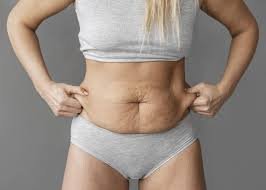 download (19) mulher analisando a região abdominal com flacidez
