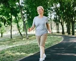 download (6) mulher madura caminhando ao ar livre com expressão de vitalidade e bem-estar